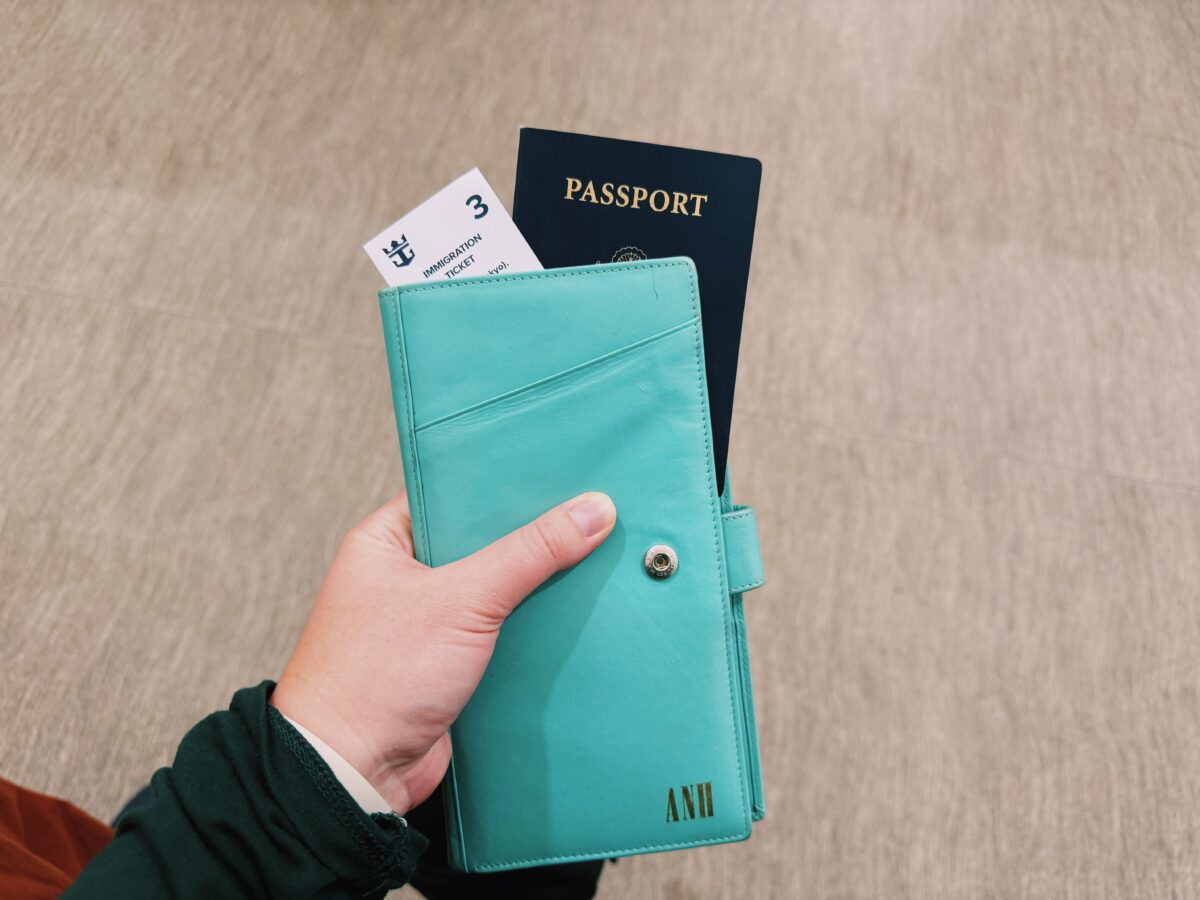 Woman has a passport holder in her hand that shows an immigration ticket and passport