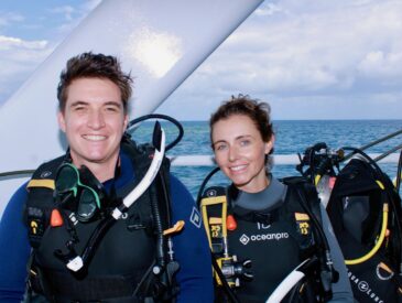 Logan and her husband smile for a picture before scuba diving at The Great Barrier Reef