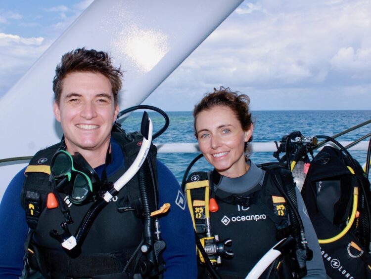 Logan and her husband smile for a picture before scuba diving at The Great Barrier Reef