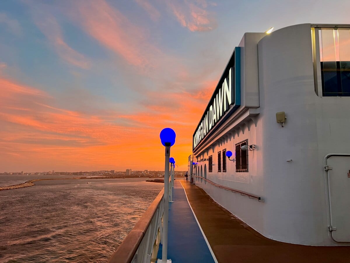 Norwegian Dawn leaving port at sunset