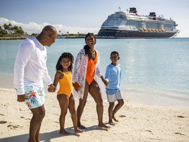 Mom, dad, son, and daughter walk on the beach at Disney's Castaway Cay