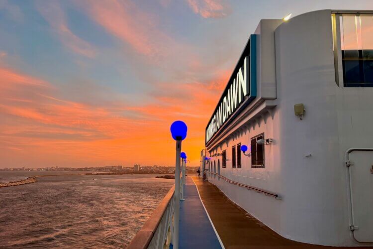 Norwegian Dawn sailing away at sunset